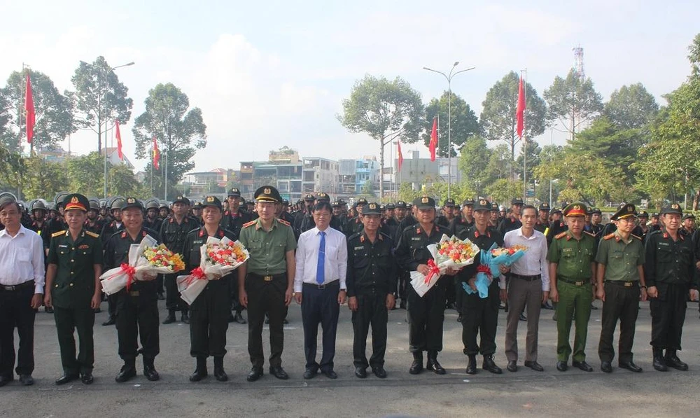 Chủ tịch UBND tỉnh Đồng Nai Cao Tiến Dũng và Giám đốc Công an tỉnh, Thiếu tướng Vũ Hồng Văn cùng các đại biểu tặng hoa chúc mừng Ban chỉ huy Trung Đoàn CSCĐ dự bị chiến đấu. Ảnh: VH.