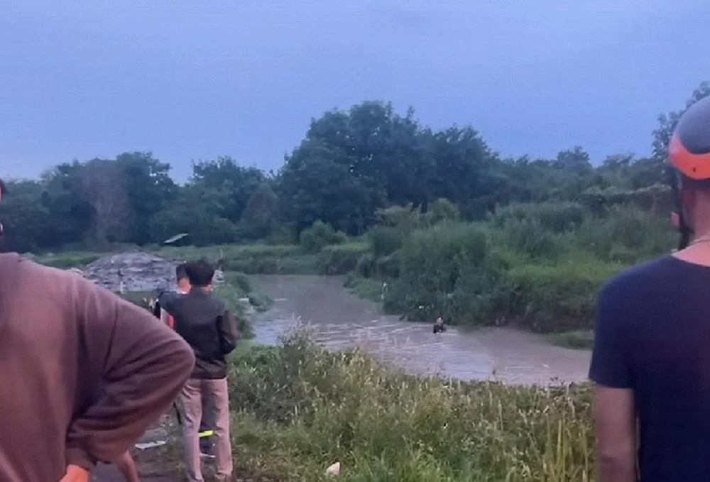 Cơ quan chức năng địa phương tổ chức tìm kiếm thi thể cháu trai bị nước cuốn mất tích. Ảnh: VH.
