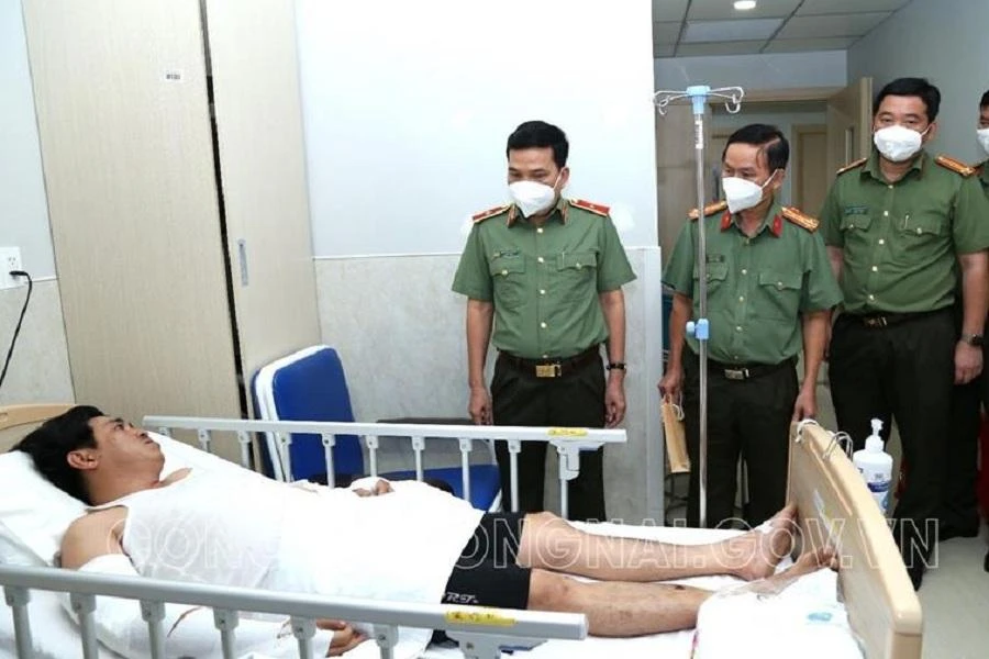 Thiếu tướng Nguyễn Sỹ Quang cùng đoàn công tác công an tỉnh Đồng Nai hỏi thăm sức khỏe và động viên thiếu tá Lâm. Ảnh: CAĐN.