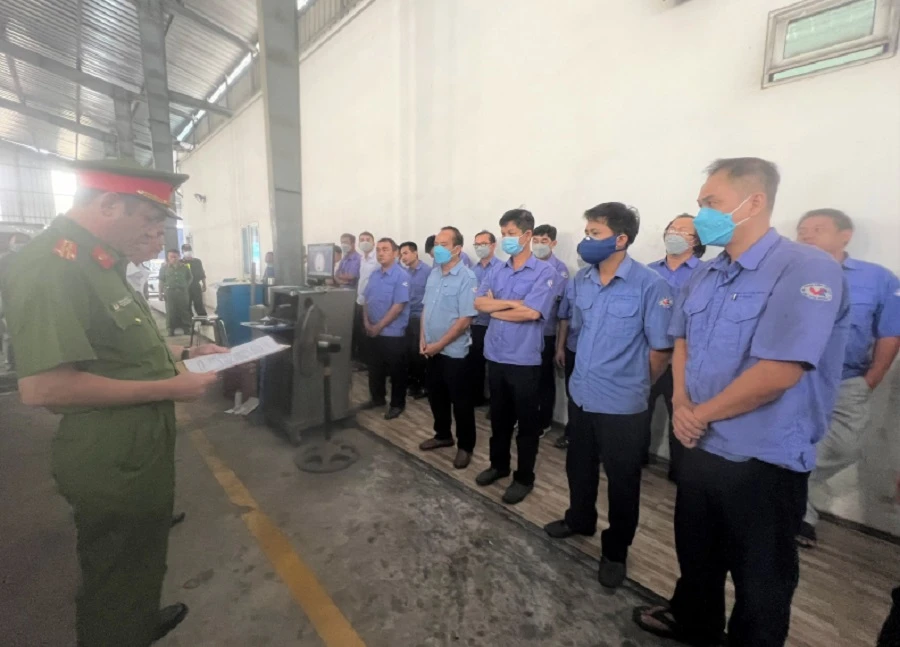 Công an đọc lệnh công bố khám xét Trung tâm đăng kiểm xe cơ giới 60-04D. Ảnh: CA.