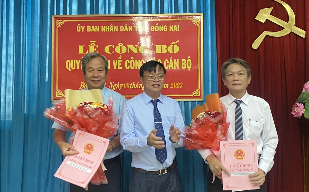 Chủ tịch UBND tỉnh Đồng Nai Cao Tiến Dũng trao quyết định nghỉ hưu cho ông Ngô Văn Toàn (bên phải) và ông Lê Mạnh Dũng. Ảnh: VH