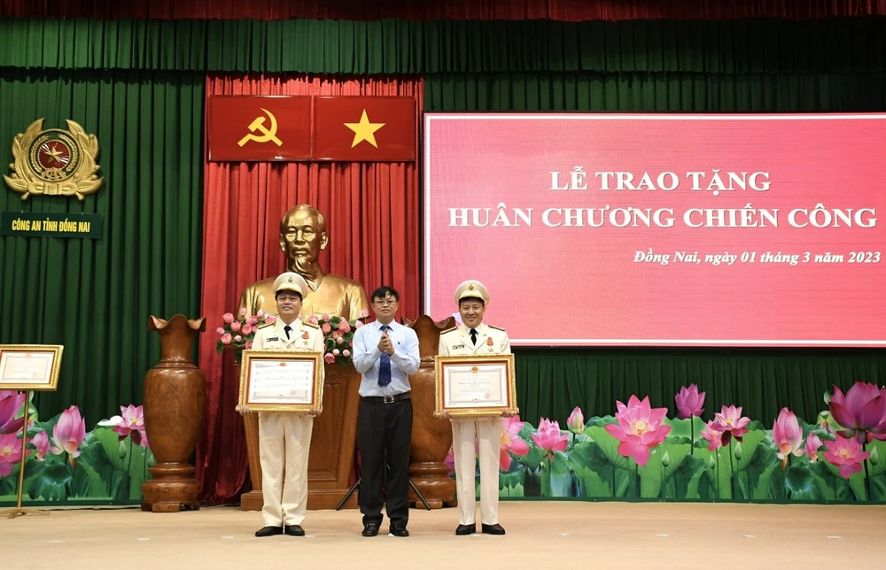 Chủ tịch UBND tỉnh Đồng Nai trao Huân chương chiến công hạng Nhất cho đại tá Nguyễn Ngọc Quang, Phó giám đốc Công an tỉnh và thượng tá Võ Thanh Hải, Phó trưởng phòng Tham mưu Công an tỉnh. Ảnh: VH