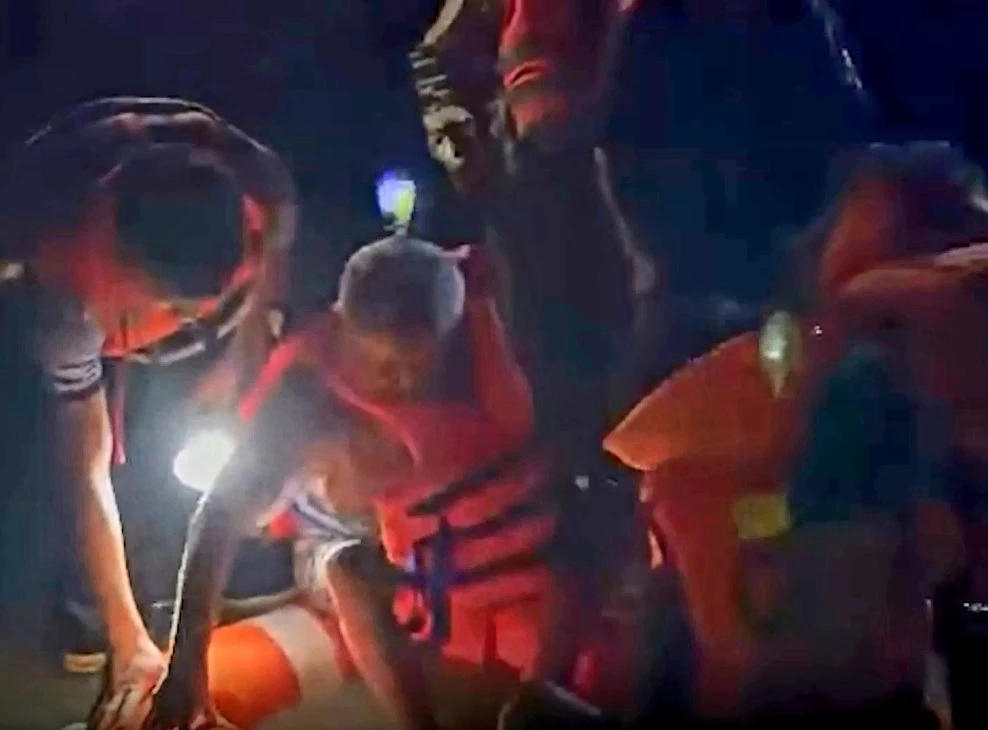 Công an huyện Định Quán đưa 2 ông cháu thoát khỏi khu vực ngập trong đêm. Ảnh: CA