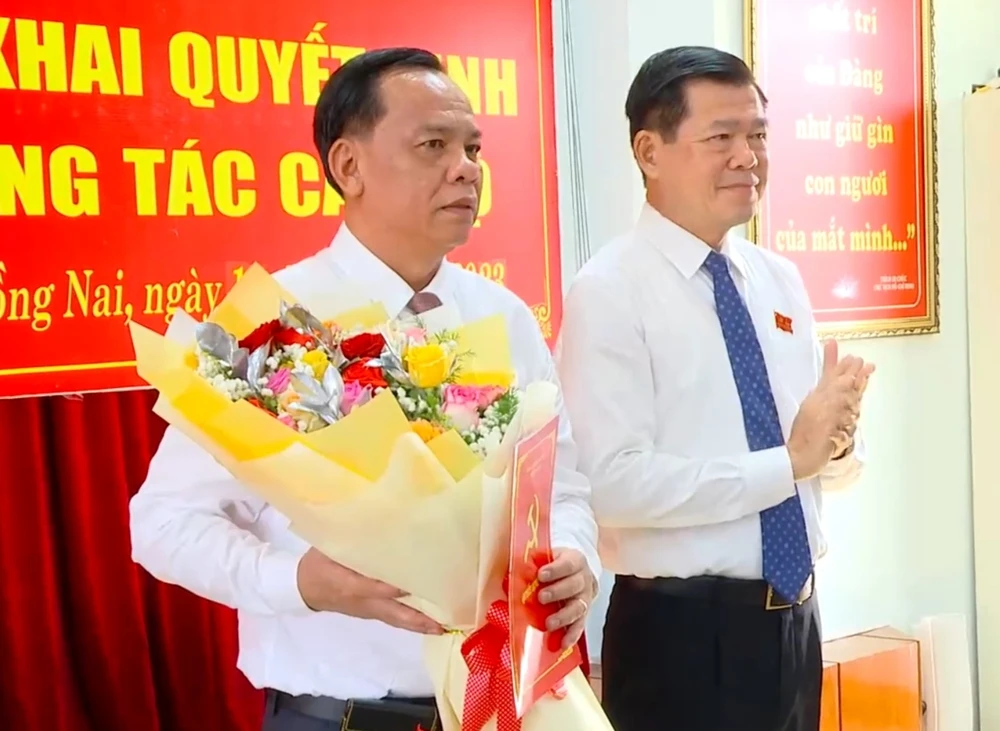 Bí thư Tỉnh uỷ Đồng Nai Nguyễn Hồng Lĩnh trao quyết định của Ban Bí thư Trung ương Đảng và tặng hoa Chúc mừng ông Võ Tấn Đức, quyền Chủ tịch UBND tỉnh Đồng Nai. Ảnh: VH.