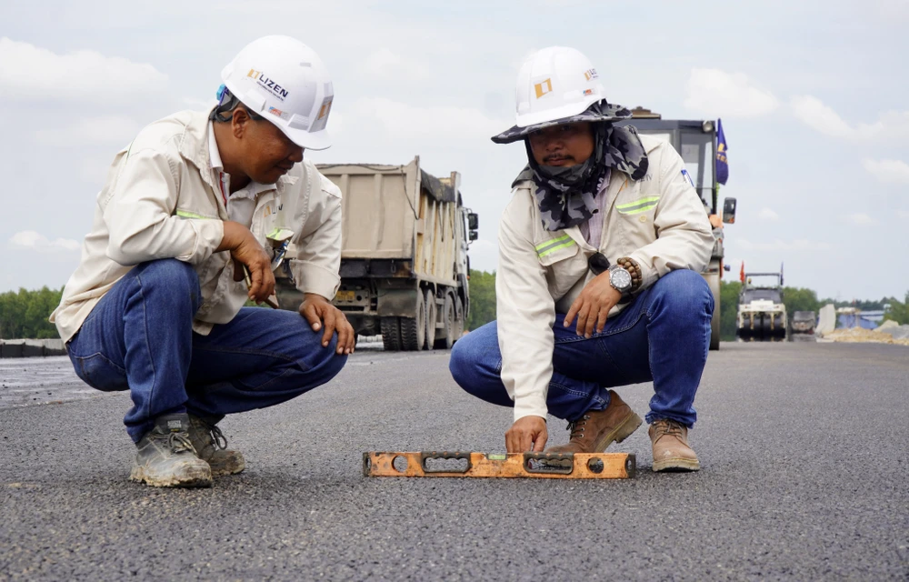 Để đảm bảo đúng kỹ thuật, các kỹ sư liên tục kiểm tra chất lượng, độ phẳng của bề mặt thảm nhựa trong quá trình lu phẳng.