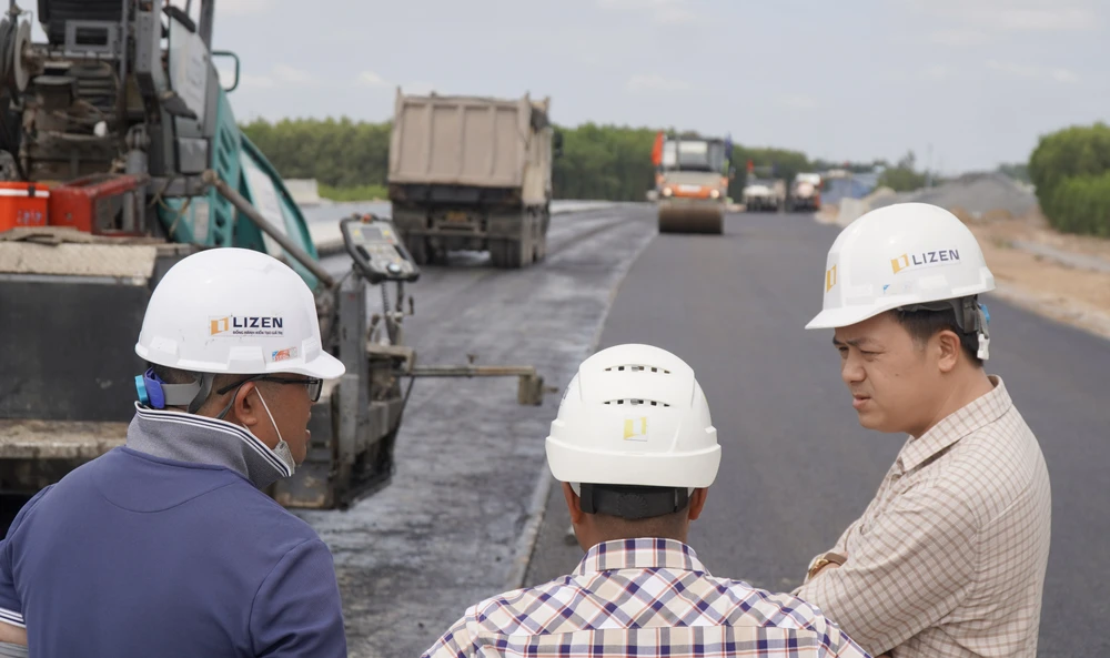 Đại diện nhà thầu trao đổi với các kỹ sư, quản lý công trình trong quá trình thực hiện trải nhảm nhựa trên cao tốc Biên Hoà - Vũng Tàu.
