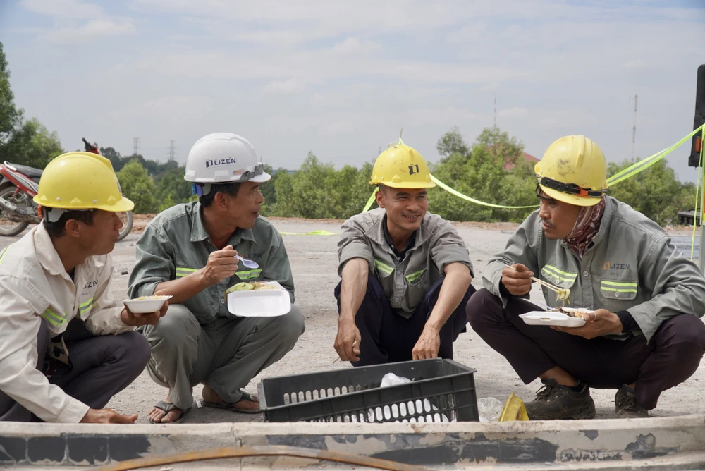 Để kịp tiến độ, các công nhân tranh thủ ngồi ăn cơm hộp ngay tại trên công trường.
