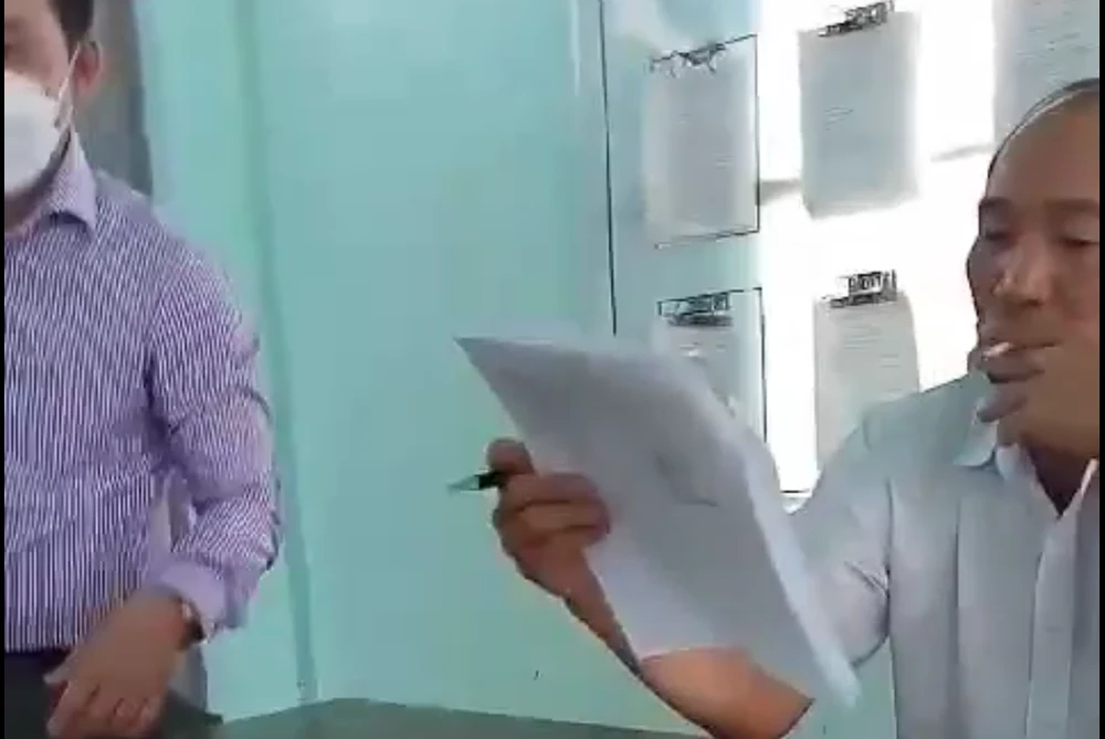 Ông Lê Đình Chiến, Phó chủ tịch UBND huyện Ea Kar (bìa phải) hút thuốc tại bàn làm việc được cho là trong giờ tiếp công dân. Ảnh cắt từ clip