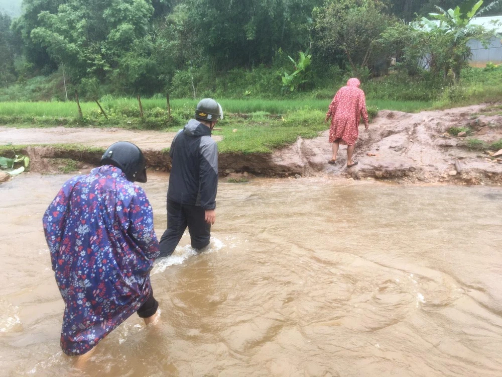 Cán bộ băng suối để đưa người dân đến nơi an toàn. Ảnh: LX