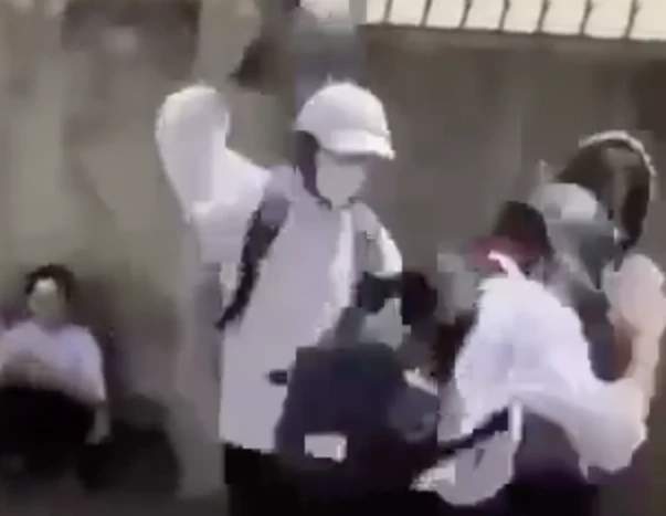 Nhóm nữ sinh dùng mũ bảo hiểm đánh bạn. Ảnh cắt từ clip
