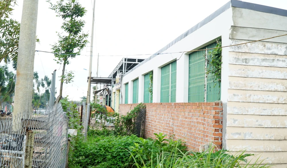 Người dân tự rào lưới B40 trước dãy ki-ốt nhà bà Hoa. Ảnh: VŨ LONG