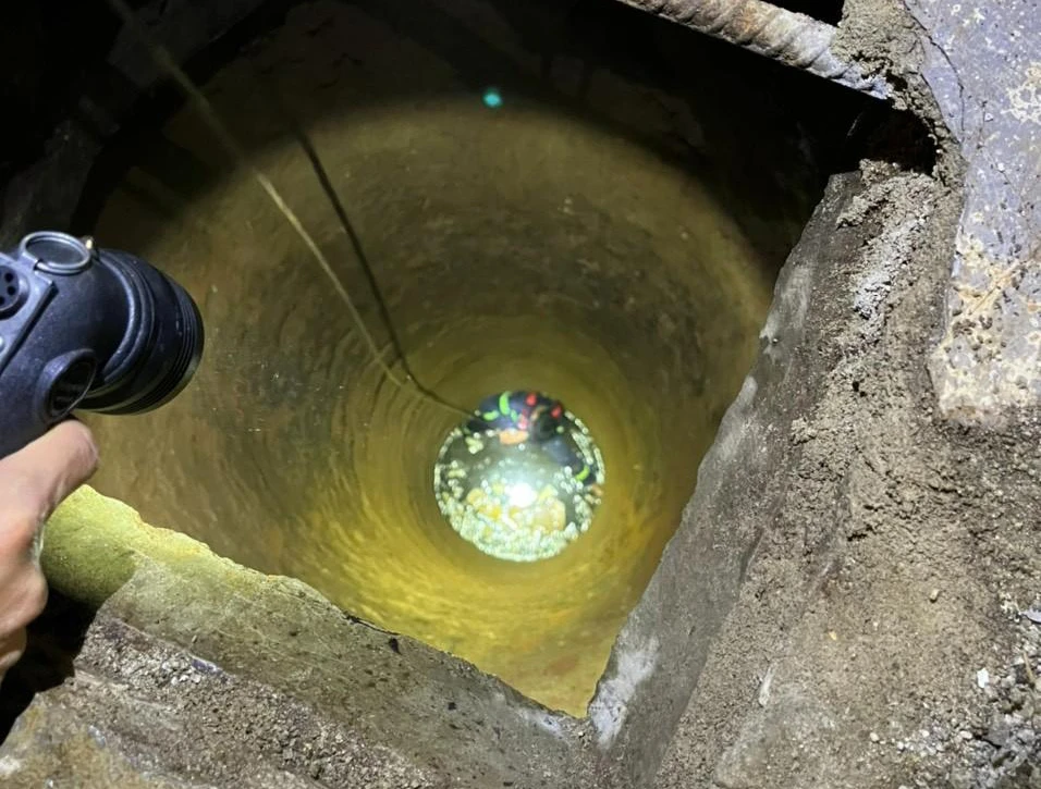 Cảnh sát tiếp cận khu vực giếng để đưa cháu bé lên trên. Ảnh: Công an cung cấp