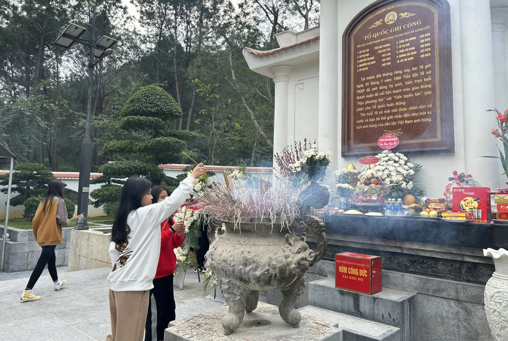 Thắp hương tại nơi yên nghỉ của 10 cô gái Ngã ba Đồng Lộc. Ảnh: VŨ LONG