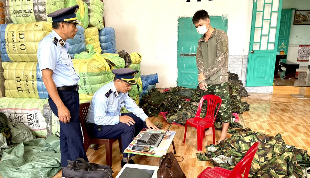 Cán bộ Cục quản lý thị trường Đắk Lắk kiểm tra cơ sở kinh doanh đồ áo. Ảnh: TT