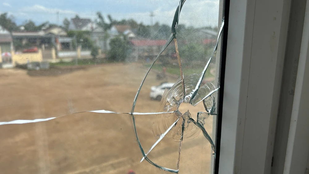 Vết đạn bắn xuyên thủng cửa kính trên tầng hai của UBND xã Ea Ktur. Ảnh: VŨ LONG