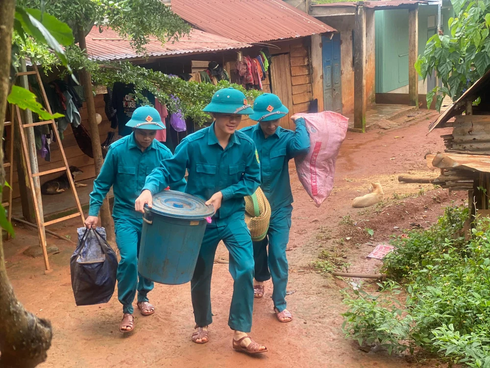 Lực lượng chức năng huyện Tuy Đức hỗ trợ di dời tài sản của người dân đến nơi an toàn. Ảnh: NC