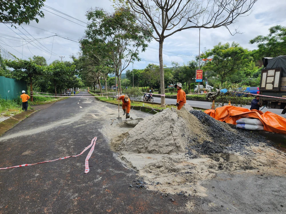 Công nhân đang sửa chữa lại đoạn đường bị hỏng. Ảnh: NH