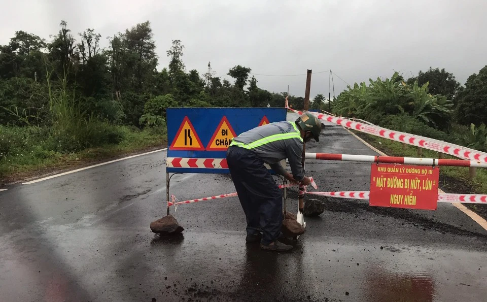 Lực lượng chức năng cắm biển cảnh báo đường hỏng. Ảnh: AX