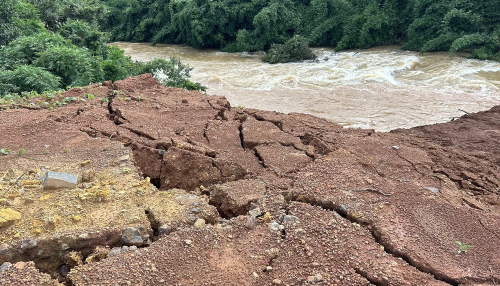 Vết nứt đất cạnh dòng suối đang chảy xiết. Ảnh: VŨ LONG