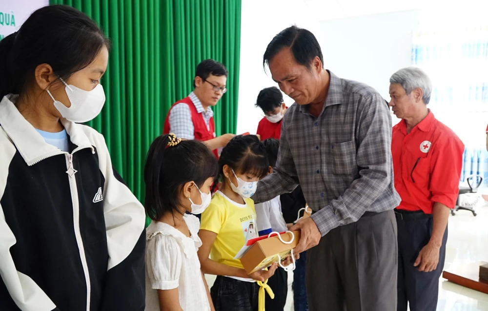 Bí thư Huyện ủy Cư Kuin Lê Thái Dũng tặng quà cho học sinh có hoàn cảnh khó khăn. Ảnh: VŨ LONG