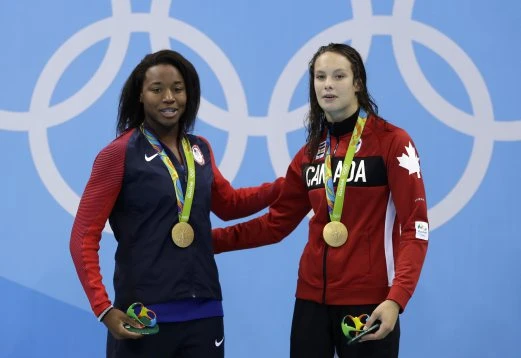 Hai vận động viên chia nhau chiếc huy chương vàng ảnh 1