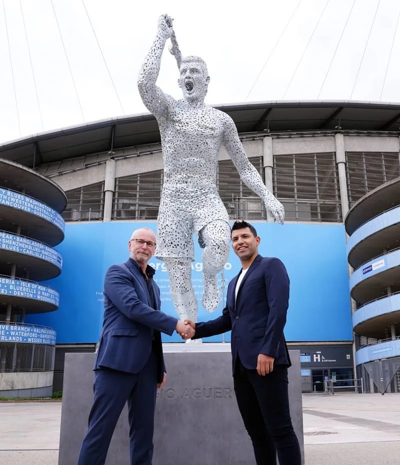 Quả là Toni Kroos nên "mua" bức tượng này về vì nó rất giống anh. Ảnh: Getty Khuôn mặt của Toni Kroos và bức tượng Aguero là một. Ảnh: Getty Đôi chân thật của Aguero...cũng cơ bắp "hình bắp chuối" hơn chứ không phải thế này. Ảnh: Getty Hẳn là Aguero mà rất giống Toni Kroos ăn mừng bàn thắng. Ảnh: Getty Bức tượng Aguero kỷ niệm 10 năm ngày vô địch Premier League của Man. "xanh" sau tượng đài Vincent Kompany, David Silva. Aguero có mặt và ký tặng fan. Ảnh: Getty