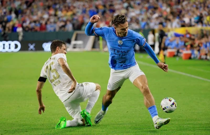 Grealish (áo xanh) của Man. City đối đầu với Thomas Muller. Haaland có nguồn sức khỏe và sức bật được đánh giá không thua gì Ronaldo. Julian Alvarez đi bóng qua Paul Wanner. Haaland chào khán giả trên sân Lambeau. Mùa hè này hàng loạt ông lớn châu Âu đến Mỹ để đá giao hữu với nhau. Grealish "không chiến" với hậu vệ Nianzou của Bayern. Các sân bóng Mỹ mùa hè này chào đón những Bayern, Man. City, Barcelona, Real Madrid... Haaland ghi bàn duy nhất trận giúp Man. City thắng "Hùm xám" 1-0. Nếu còn khoác áo Borussia Dortmund, Haaland và đồng đội dễ gì đánh bại "Hùm xám" Bayern.