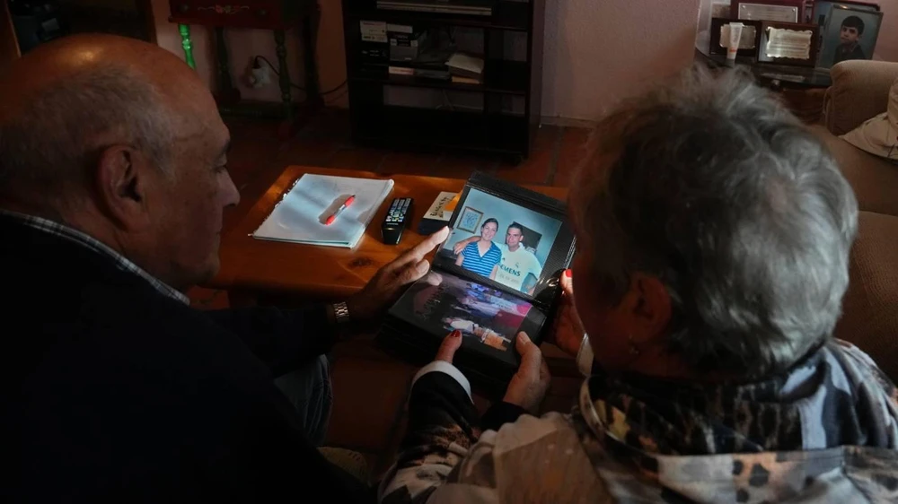 Bố mẹ Sanchez nhìn tấm hình con trai và bạn gái. Ảnh: AP