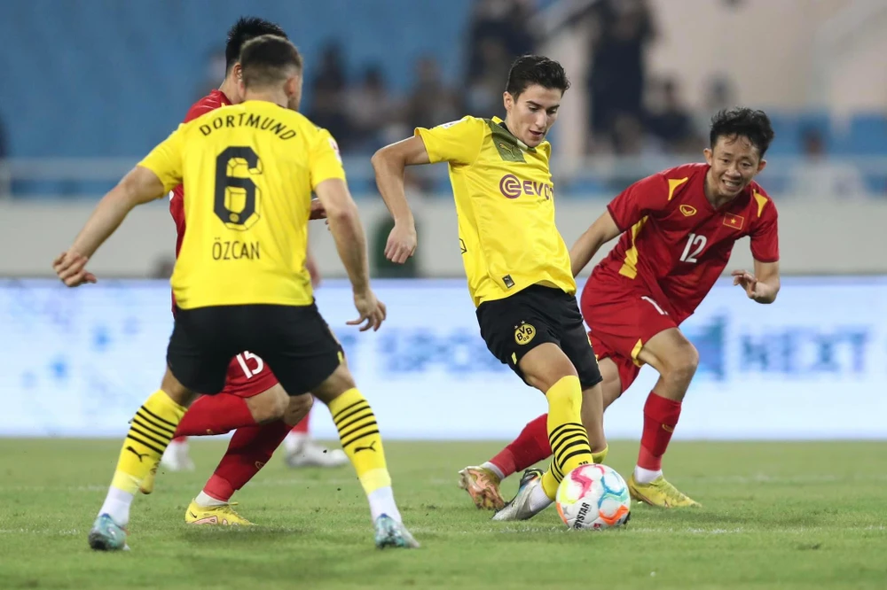 Tuy nhỏ con, nhưng Ngọc Quang chơi rất xông xáo trước các cầu thủ Dortmund. Ảnh: A.P