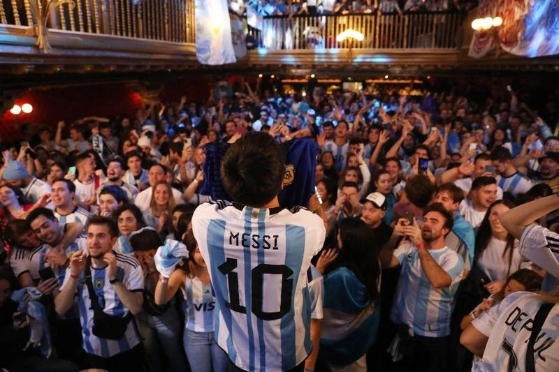 "Messi" có mặt ở Madrid ăn mừng chiến thắng. Ảnh: Reuters Người phụ nữ bán hàng trong chợ ở Argentina bật khóc khi Di Maria ghi bàn thứ hai cho Argentina. Ảnh: Reuters Ở trung tâm Tampines, Singapore, fan Argentina ăn mừng. Ảnh: S.T Singapore lập các trung tâm truyền hình trực tiếp để phục vụ người dân và cả người nước ngoài công tác và du lịch ở Singapore xem. Ảnh: S.T Các fan chúc mừng nhau khi Messi mở điểm từ chấm 11m, đây là hình ảnh tại Lo De Diego, Argentina. Ảnh: Reuters Tại thủ đô Buenos Aires của Argentina...mọi người thức dậy xem chung kết và ăn mừng. Ảnh: Reuters Tại một trung tâm văn hóa ở Buenos Aires. Ảnh: Reuters ...Còn trên sân Lusail, nơi diễn ra trận chung kết có khoảng 10 ngàn người Argentina, không kể fan của Argentina. Ảnh: Reuters