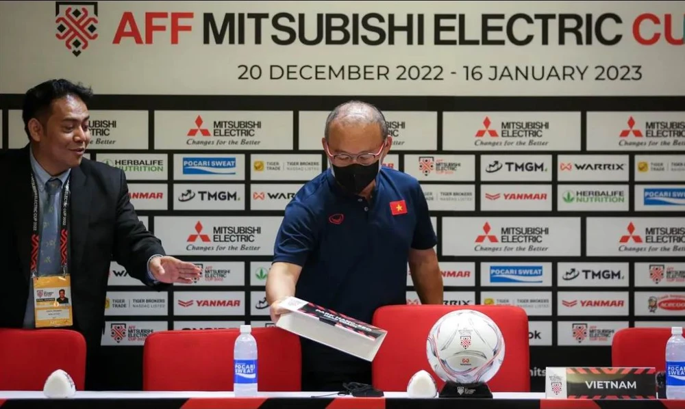 HLV Park Hang-seo "soi" có đúng tên mình hay không trước buổi họp báo. Ảnh: Bola.