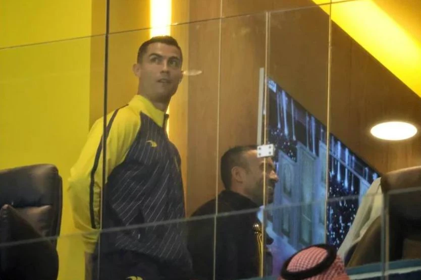 Ronaldo quan sát sân Mrsool qua cửa kính. Ronaldo chào fan khi hiện diện trên khu VIP.
