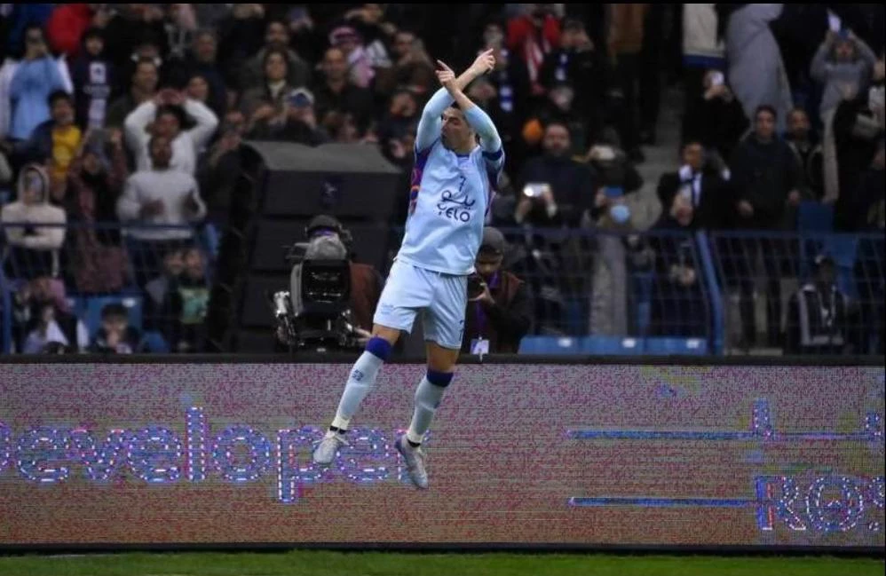 ...và dáng ăn mừng quen thuộc của đội trưởng Saudi All Star XI trên sân King Fadh, Riyadh. Một fan của Ronaldo trên sân King Fadh. Ngôi sao Pháp Mbappe cũng có bàn thắng. Một pha va chạm rất nặng giữa thủ môn Navas của PSG với Ronaldo. Jang Hun-soo san bằng tỉ số 3-3 cho Liên quân. Ronaldo vẫn rất dũng mãnh ở tuổi 37. Messi trong một pha chạm trán với thủ môn Al Owais của Liên quân Al Nassr-Al Hilal. Mbappe và... ông anh Ronaldo. Một trận giao hữu quá nhiều siêu sao nhưng tính đối kháng không cao. Mbappe góp một bàn thắng vào chiến thắng 5-4 của đội khách đến từ thủ đô nước Pháp. Juan Bernat của PSG bị trọng tài người Qatar rút thẻ đỏ. Trợ lý của Liên quân bắt tay Ronaldo. Tổ trọng tài người Qatar điều hành trận đấu, Ronaldo là đội trưởng của Liên quân còn Marquinhos làm đội trưởng PSG. Trận đấu thắng lớn về mặt tài chính.