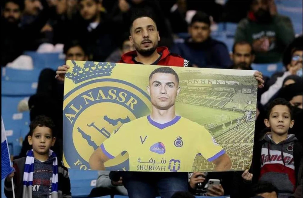 Một fan của Ronaldo trên sân King Fadh. Ngôi sao Pháp Mbappe cũng có bàn thắng. Một pha va chạm rất nặng giữa thủ môn Navas của PSG với Ronaldo. Jang Hun-soo san bằng tỉ số 3-3 cho Liên quân. Ronaldo vẫn rất dũng mãnh ở tuổi 37. Messi trong một pha chạm trán với thủ môn Al Owais của Liên quân Al Nassr-Al Hilal. Mbappe và... ông anh Ronaldo. Một trận giao hữu quá nhiều siêu sao nhưng tính đối kháng không cao. Mbappe góp một bàn thắng vào chiến thắng 5-4 của đội khách đến từ thủ đô nước Pháp. Juan Bernat của PSG bị trọng tài người Qatar rút thẻ đỏ. Trợ lý của Liên quân bắt tay Ronaldo. Tổ trọng tài người Qatar điều hành trận đấu, Ronaldo là đội trưởng của Liên quân còn Marquinhos làm đội trưởng PSG. Trận đấu thắng lớn về mặt tài chính.