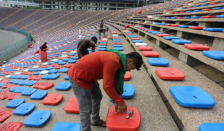 ...Công nhân dùng búa để bắt đinh gắn chặt ghế vào bê tông. Ảnh: CTP Khi vào bên trong sân Olympic ở Phnom Penh này cảm giác rất giống bên trong sân Cần Thơ. Ảnh: CTP Lắp đặt ghế tạm thời là hạng mục cuối cùng của sân Olympic chờ ngày 29-4 quả bóng môn bóng đá SEA Games 32...lăn. Ảnh: CTP