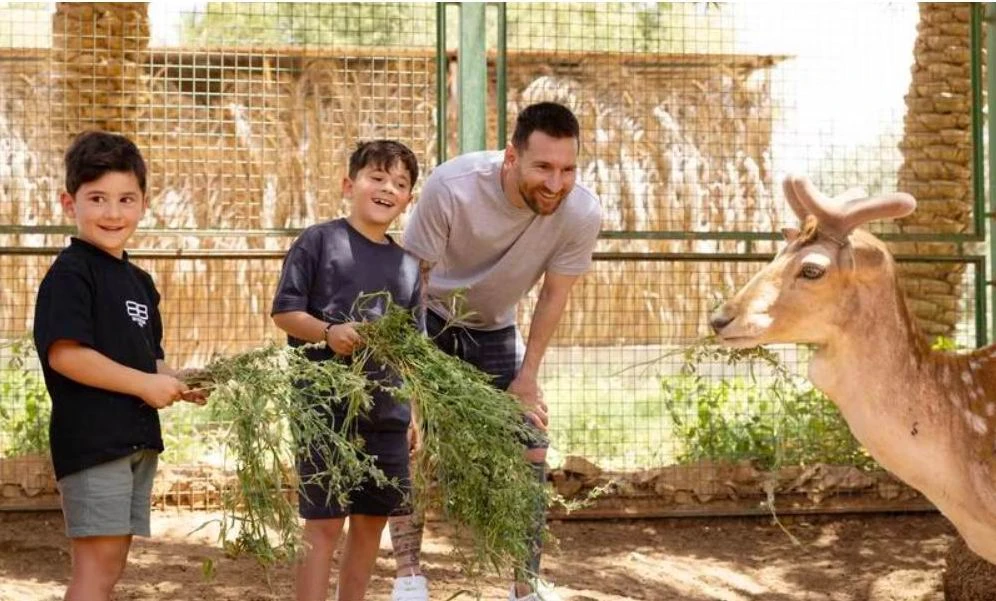 Messi cùng hai con trai đang đùa với chú hươu sao ở vườn bách thú Riyadh. Ảnh: A.N
