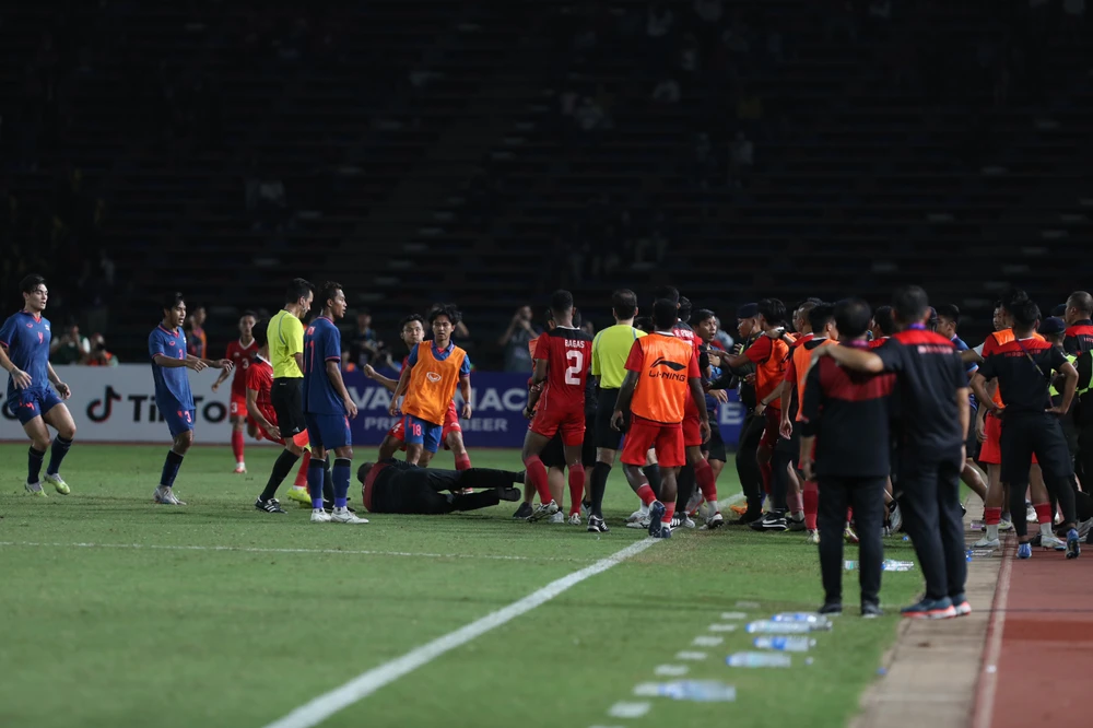 Trưởng đoàn Sumardji đã té ngã, nhưng các cầu thủ Thái Lan vẫn lao vào đạp và tấn công. Ảnh: ANH PHƯƠNG Cầu thủ Koman Teguh (số 4, Indonesia, đỏ) và thủ môn Yoponwit (vàng) của Thái Lan bị trọng tài Kasim rút thẻ đỏ trong tình huống bạo lực này. Trưởng đoàn Sumardji bị tấn công không thương tiếc là vì ăn mừng quá khiêu khích phía Thái Lan.