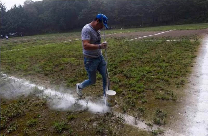 Một nhân viên của sân đang rải lại lằn vôi sân bằng chất bột trắng. Ảnh: AFP