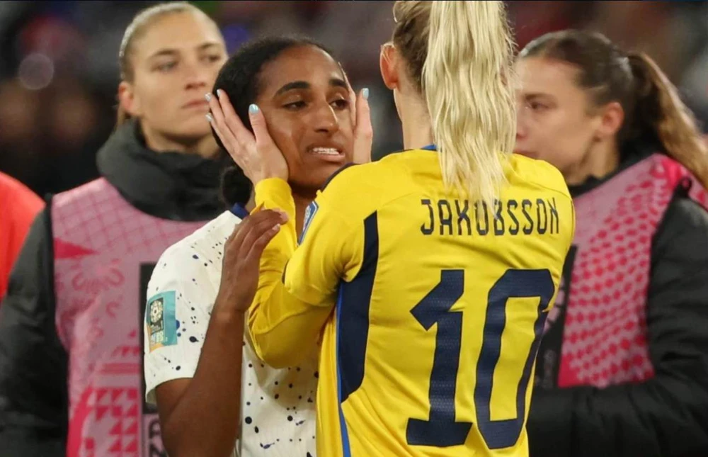 Jakobsson của Thụy Điển sau khi đánh bại tuyển Mỹ trong loạt luân lưu đã vỗ về đồng nghiệp trẻ Mỹ Naomi Girma mới 20 tuổi. Ảnh: SMH Bà chị đội trưởng Lindsey Horan vỗ về cô em gái Sophia Smith, 21 tuổi, người đá hỏng quả luân lưu trong loạt sút năm quả. Ảnh: SMH. Hai "tội đồ" của tuyển Mỹ sút hỏng phạt đền trong loạt sút 5 quả gồm bà chị cả Megan Rapinoe và Sophia Smith. Ảnh:SMH World Cup 2019, Rapinoe có hai danh hiệu cá nhân gồm cầu thủ xuất sắc nhất giải và vua phá lưới (5 bàn), bốn năm sau phong độ của cô đã xuống ở tuổi 37, ít ra sân. Ảnh: SMH. Rapinoe...cắn rứt vì mình sút hỏng phạt đền. Ảnh: SMH Các tuyển thủ Mỹ an ủi nhau sau khi chính thức thành cựu vô địch sau loạt luân lưu thứ 7. Ảnh: SMH. Thủ môn Naeher quờ quạng trước cú sút của Hurtig ở loạt sút thứ bảy, bóng đã qua vạch vôi...1mm. Ảnh: SMH. Sau khi trọng tài Stephanie Frappart công nhận bàn thắng ở loạt luân lưu quyết định, Hurtig ăn mừng cùng đồng đội vào tứ kết. Ảnh: SMH.