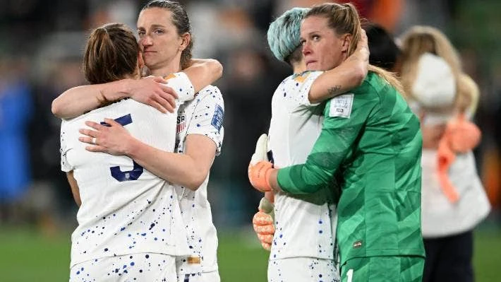 Các tuyển thủ Mỹ an ủi nhau sau khi chính thức thành cựu vô địch sau loạt luân lưu thứ 7. Ảnh: SMH. Thủ môn Naeher quờ quạng trước cú sút của Hurtig ở loạt sút thứ bảy, bóng đã qua vạch vôi...1mm. Ảnh: SMH. Sau khi trọng tài Stephanie Frappart công nhận bàn thắng ở loạt luân lưu quyết định, Hurtig ăn mừng cùng đồng đội vào tứ kết. Ảnh: SMH.