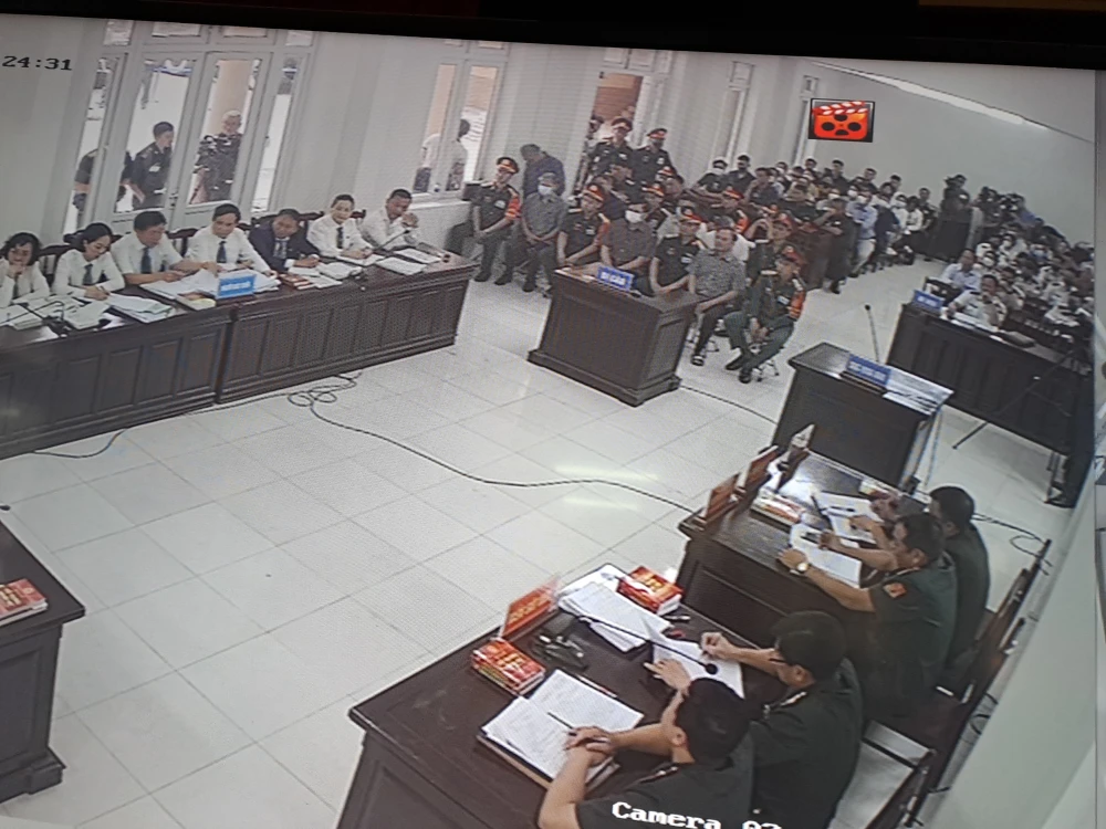 Phóng viên tác nghiệp tại phòng báo chí, theo dõi phiên tòa qua màn hình.