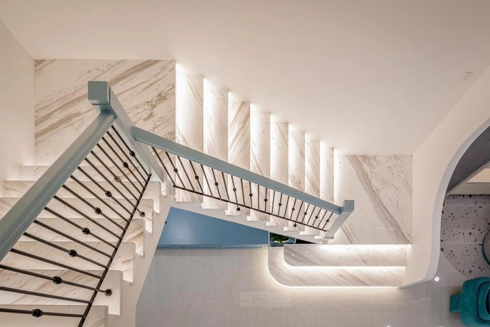 Dưới mỗi bậc thang đều được gắn đèn led, đặc biệt phần trần cong màu xanh uốn lượn đẹp mắt.