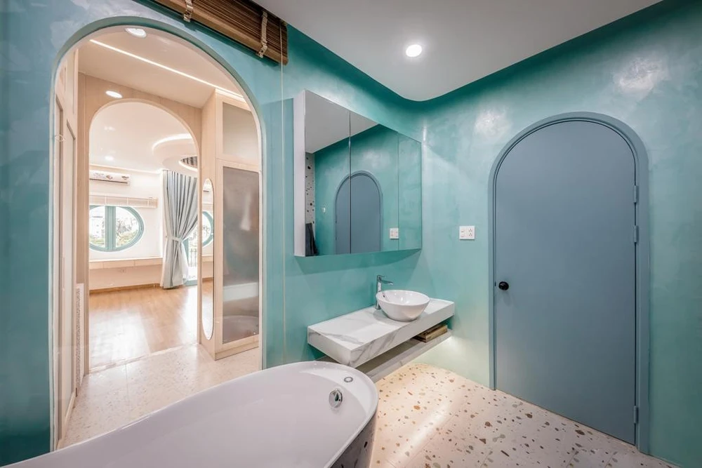 Khác với bên ngoài, kiến trúc sư sử dụng toàn bộ sắc xanh cho nhà vệ sinh để làm nổi bật không gian, xanh pastel và xanh lục của gạch mosaic ốp tường.