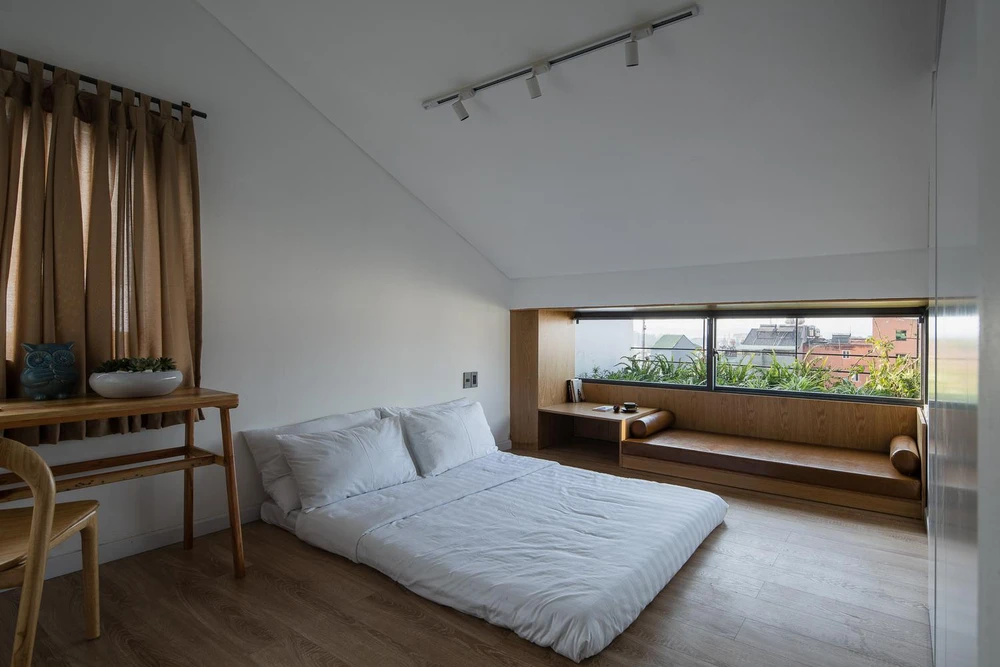 Phòng ngủ với gam màu vàng của sàn gỗ giúp không gian thêm sang trọng và hiện đại, tường trắng kết hợp thêm cửa sổ gam màu xanh mát nhìn ra view khá đẹp.