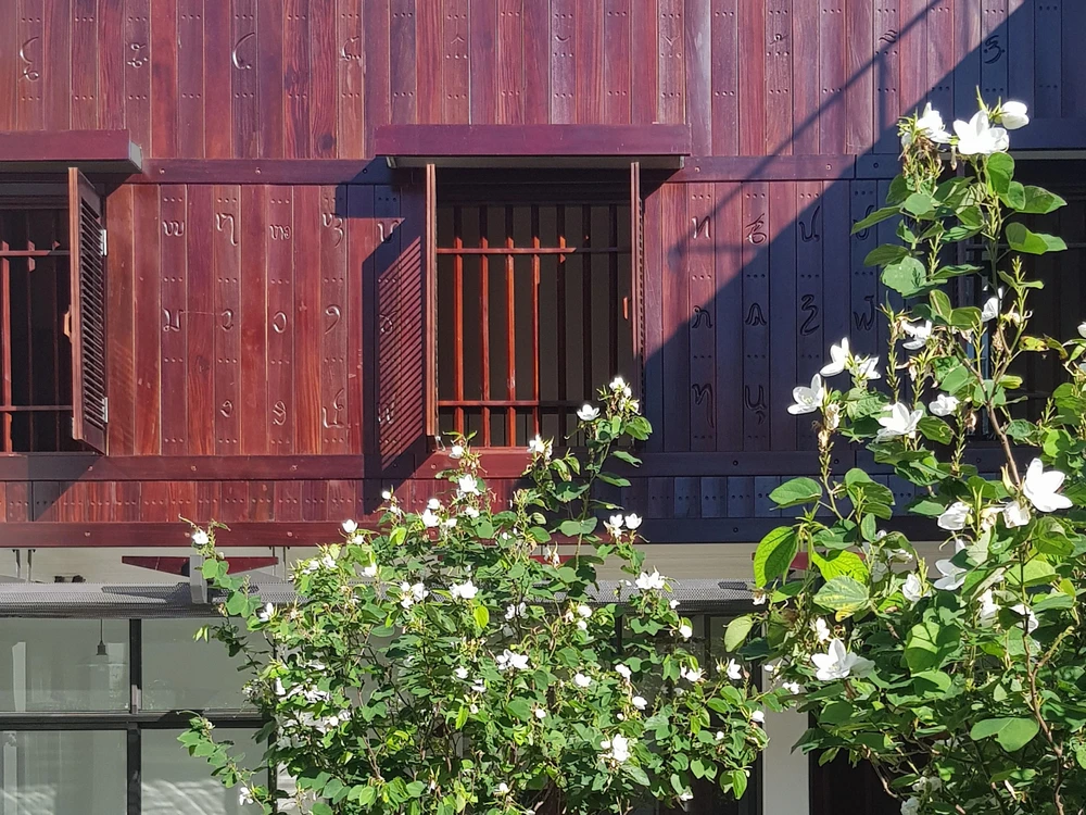 Chữ viết cổ của người Thái trên các bức tường gỗ là điểm nhấn chính của ngôi nhà.