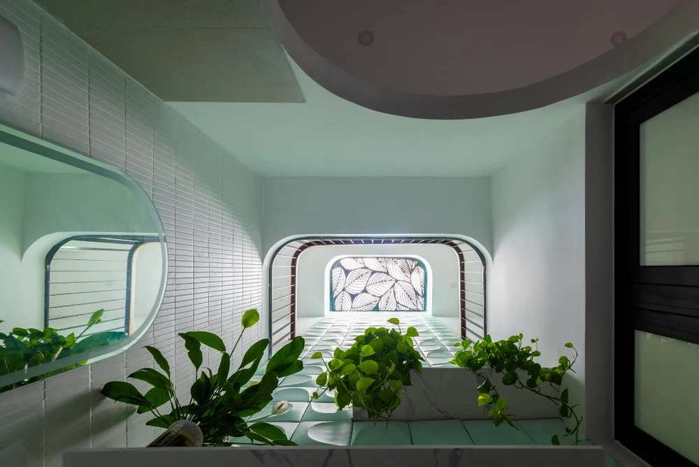 Giữa khoảng thông tầng, kiến trúc sư bố trí thêm cây xanh để tạo nên sự xanh mát cho ngôi nhà.