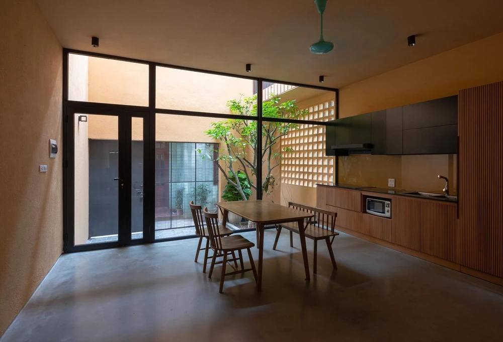 Bàn ăn lớn từ gỗ cùng tông màu với gian bếp.