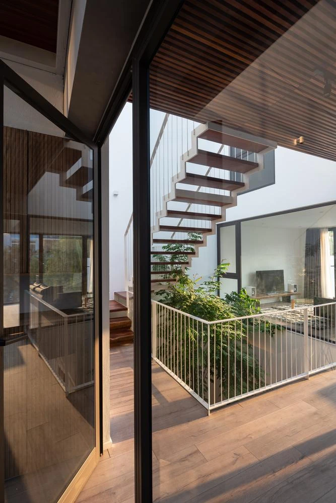 Cầu thang và giếng trời được thiết kế giữa nhà, kết nối các tầng trên và không gian riêng tư.