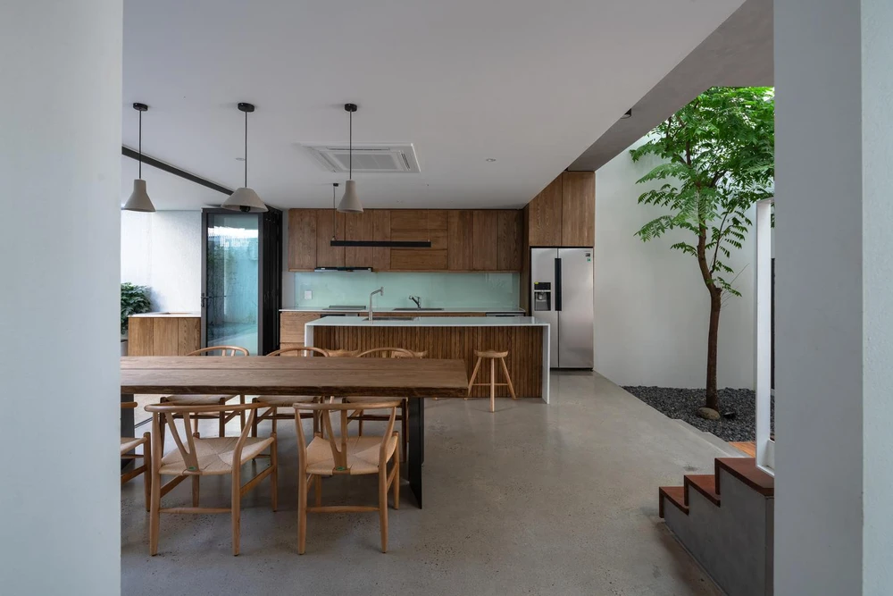 Bếp và bàn ăn nằm giữa hai khoảng sân trước và sân sau.