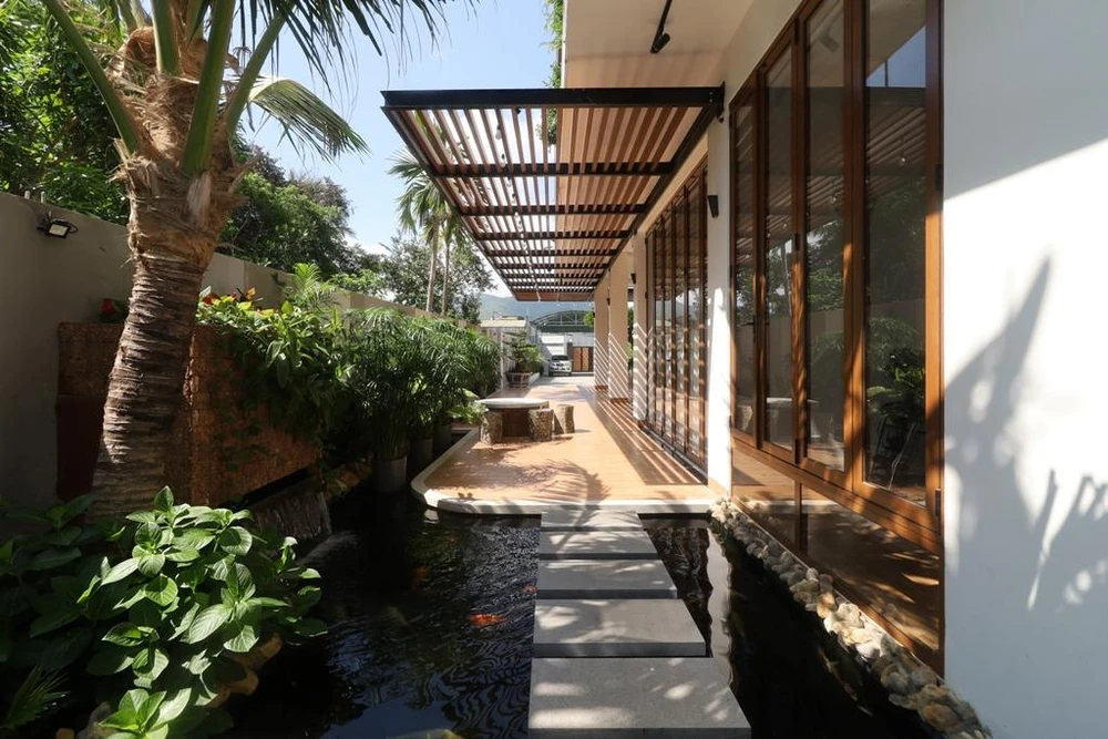 Những khoảng hiên và ban công rộng trải theo mặt tiền hướng Đông, kết hợp với lam chắn nắng và cửa chớp.